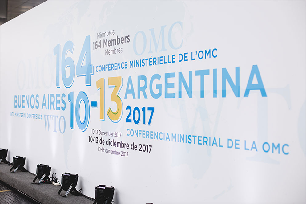 Banner welcoming 164 delegates to the 11th Ministerial Conference of the World Trade Organisation in Buenos Aires in Spanish, French, and English.